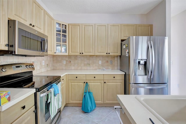 1562 NW 157th Ave, Pembroke Pines, FL 33028 - kitchen with stainless steel appliances, light brown cabinets, light countertops, backsplash, and a textured ceiling