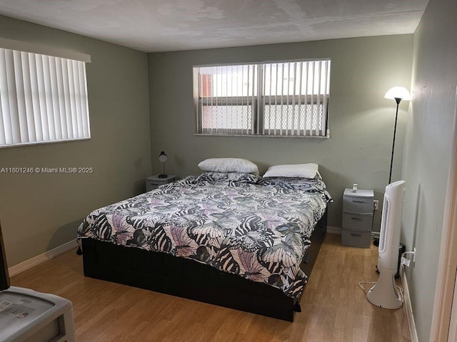 bedroom with light wood-style flooring and baseboards