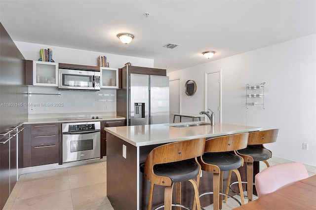 1900 N Bayshore Dr Unit 2915, Miami, FL 33132 - kitchen featuring appliances with stainless steel finishes, a sink, a breakfast bar area, and glass insert cabinets