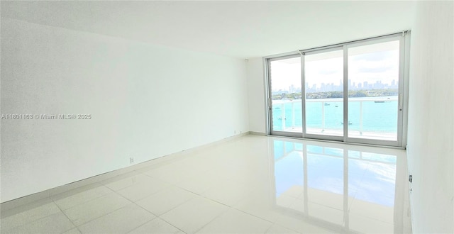 1000 W Ave Unit 715, Miami Beach, FL 33139 - tiled empty room featuring a water view, a wall of windows, and a city view