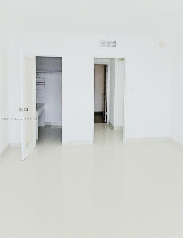 1000 W Ave Unit 715, Miami Beach, FL 33139 - unfurnished bedroom featuring a walk in closet, a closet, and baseboards