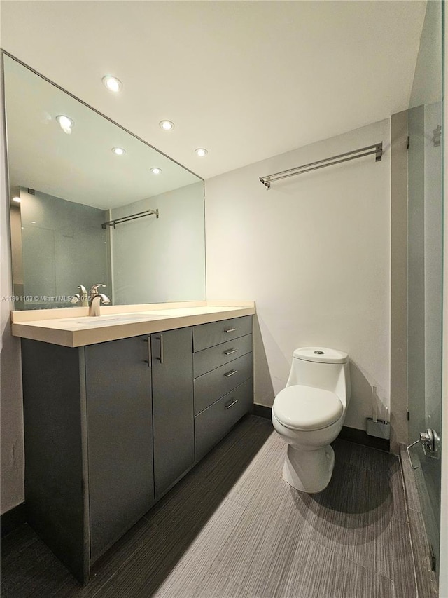 1000 W Ave Unit 715, Miami Beach, FL 33139 - bathroom featuring toilet, vanity, recessed lighting, baseboards, and wood finished floors