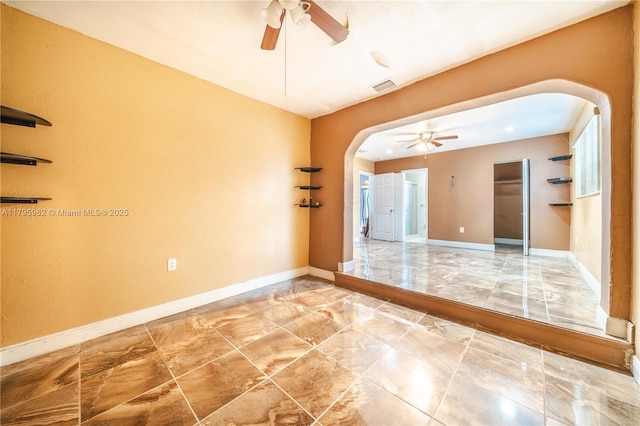 18000 NW 6th Pl, Miami Gardens, FL 33169 - unfurnished room with arched walkways, a ceiling fan, marble look tiles, and baseboards