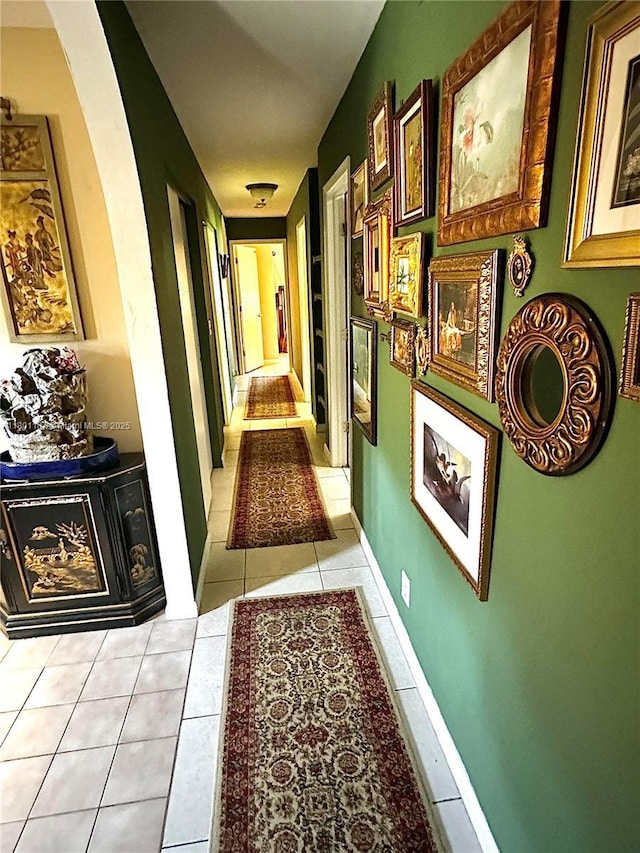 hall featuring arched walkways and light tile patterned floors