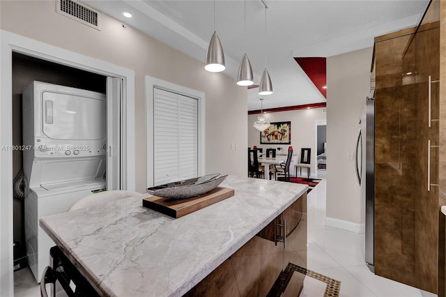 16275 Collins Ave Unit 2002, Sunny Isles Beach, FL 33160 - kitchen featuring stacked washing machine and dryer, light tile patterned floors, modern cabinets, pendant lighting, and light stone countertops