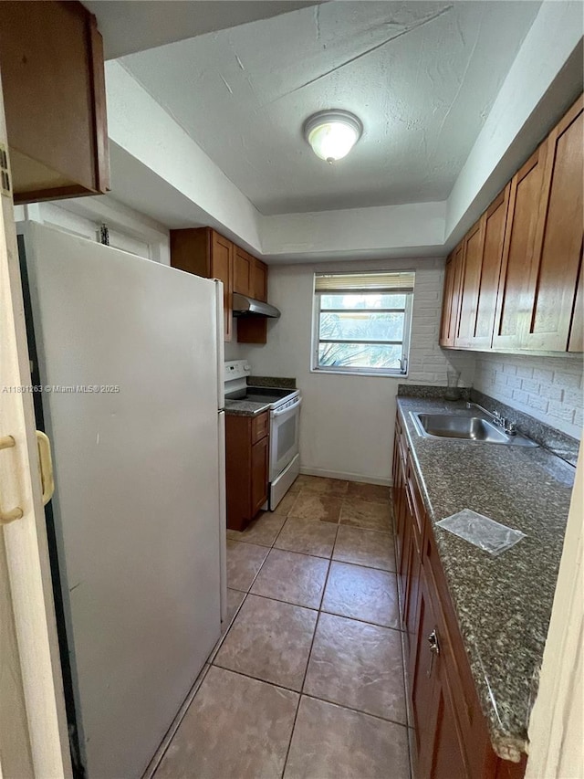 7841 Dunham Blvd Unit 6, Miami, FL 33138 - kitchen featuring white appliances, a sink, dark countertops, under cabinet range hood, and brown cabinetry