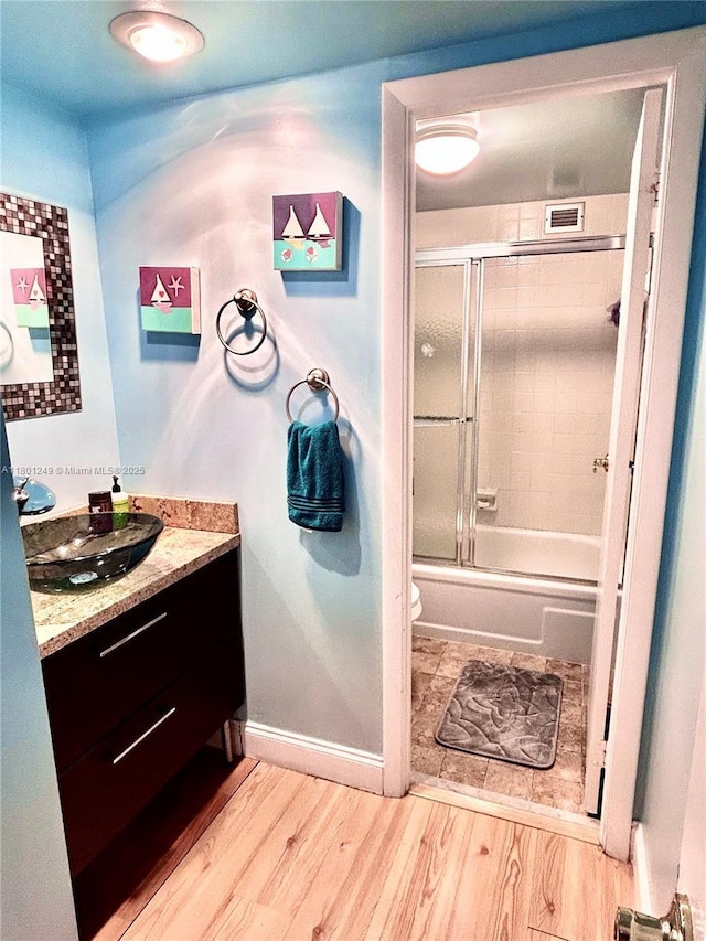 600 Three Islands Blvd Unit 905, Hallandale Beach, FL 33009 - bathroom with wood finished floors, vanity, toilet, combined bath / shower with glass door, and baseboards