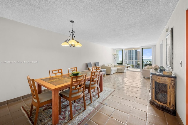 121 Golden Isles Dr Unit 905, Hallandale Beach, FL 33009 - dining space featuring a textured ceiling, a chandelier, and light tile patterned flooring