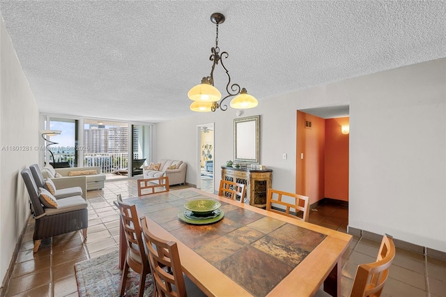 121 Golden Isles Dr Unit 905, Hallandale Beach, FL 33009 - tiled dining space featuring a textured ceiling and baseboards