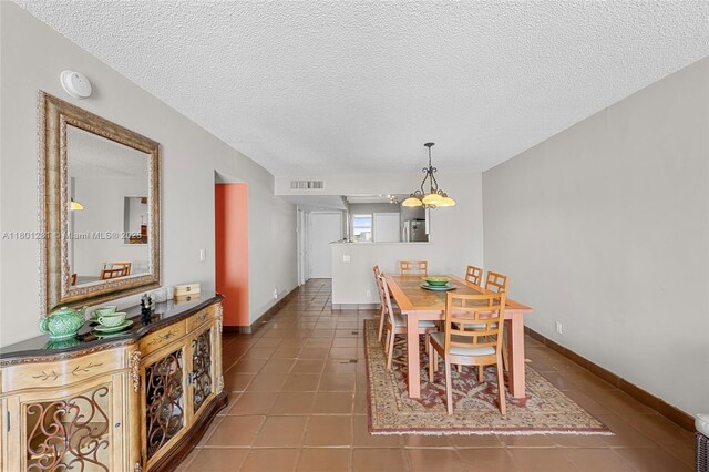 121 Golden Isles Dr Unit 905, Hallandale Beach, FL 33009 - dining area with a textured ceiling, tile patterned flooring, and baseboards