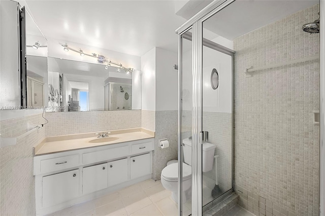 121 Golden Isles Dr Unit 905, Hallandale Beach, FL 33009 - bathroom with tile walls, a shower stall, toilet, vanity, and tile patterned flooring
