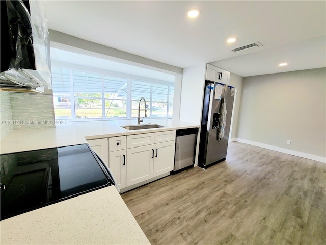 4230 NW 52nd Ave, Lauderdale Lakes, FL 33319 - kitchen featuring stainless steel appliances, a sink, light wood finished floors, recessed lighting, and light countertops