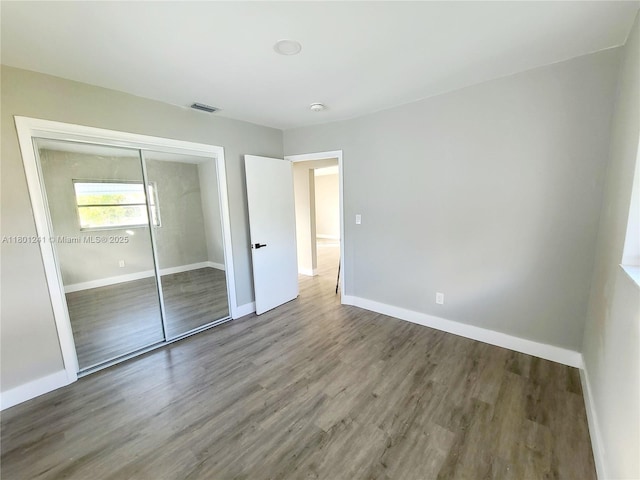 4230 NW 52nd Ave, Lauderdale Lakes, FL 33319 - unfurnished bedroom featuring baseboards, wood finished floors, and a closet