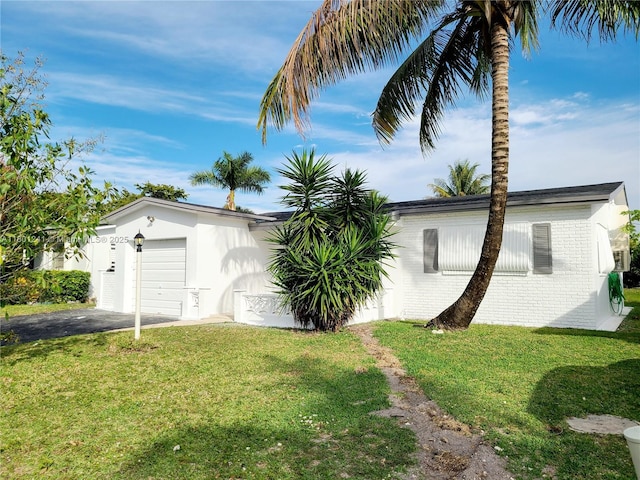 4230 NW 52nd Ave, Lauderdale Lakes, FL 33319 - view of grassy yard with an attached garage and asphalt driveway