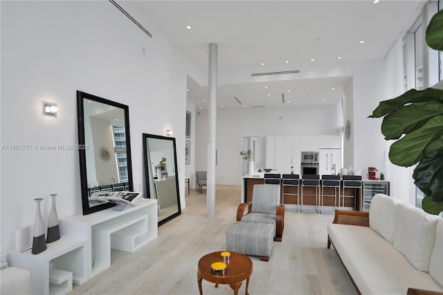 495 Brickell Ave Unit 4102, Miami, FL 33131 - living area with a towering ceiling, beverage cooler, light wood-style flooring, and recessed lighting