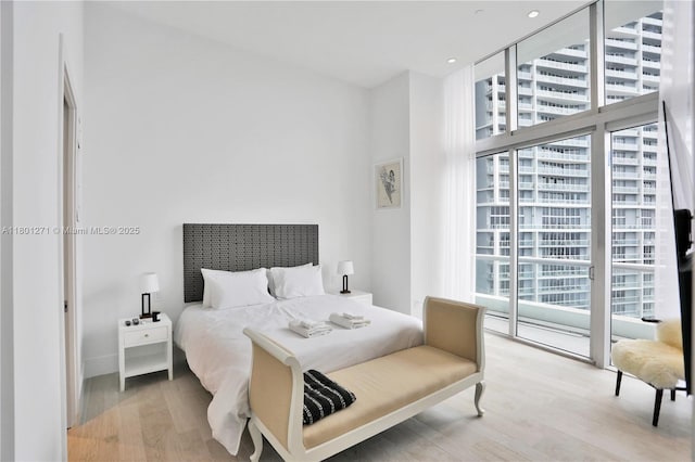 495 Brickell Ave Unit 4102, Miami, FL 33131 - bedroom with wood finished floors, access to outside, baseboards, and a wall of windows