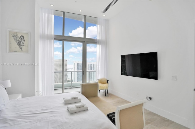 495 Brickell Ave Unit 4102, Miami, FL 33131 - bedroom featuring a high ceiling, access to exterior, multiple windows, baseboards, and wood finished floors