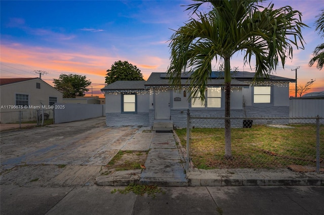 621 E 8th St, Hialeah, FL 33010 - view of front of house featuring roof mounted solar panels, concrete driveway, stone siding, and stucco siding