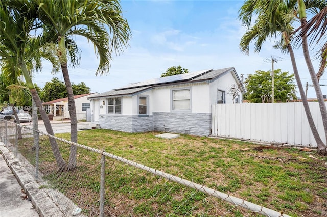 621 E 8th St, Hialeah, FL 33010 - view of front of house with stone siding and roof mounted solar panels