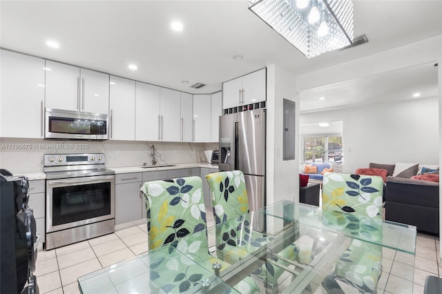 621 E 8th St, Hialeah, FL 33010 - kitchen with appliances with stainless steel finishes, light countertops, light tile patterned floors, open floor plan, and white cabinetry