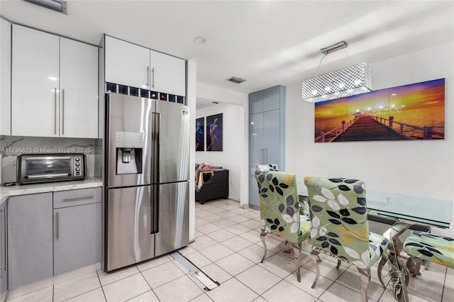 621 E 8th St, Hialeah, FL 33010 - kitchen featuring stainless steel fridge with ice dispenser, light countertops, white cabinets, light tile patterned floors, and gray cabinets