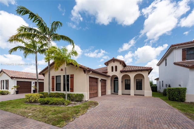 8513 NW 41st St, Cooper City, FL 33024 - mediterranean / spanish home featuring an attached garage, stucco siding, decorative driveway, and a tiled roof