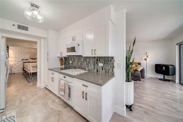 1201 S Ocean Dr Unit 1105N, Hollywood, FL 33019 - kitchen featuring white appliances, white cabinets, tasteful backsplash, and dark countertops