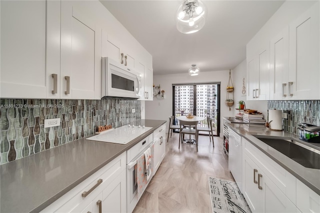 1201 S Ocean Dr Unit 1105N, Hollywood, FL 33019 - kitchen with white appliances, white cabinetry, decorative backsplash, and a sink