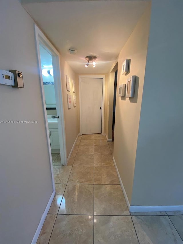 hall with baseboards and light tile patterned floors