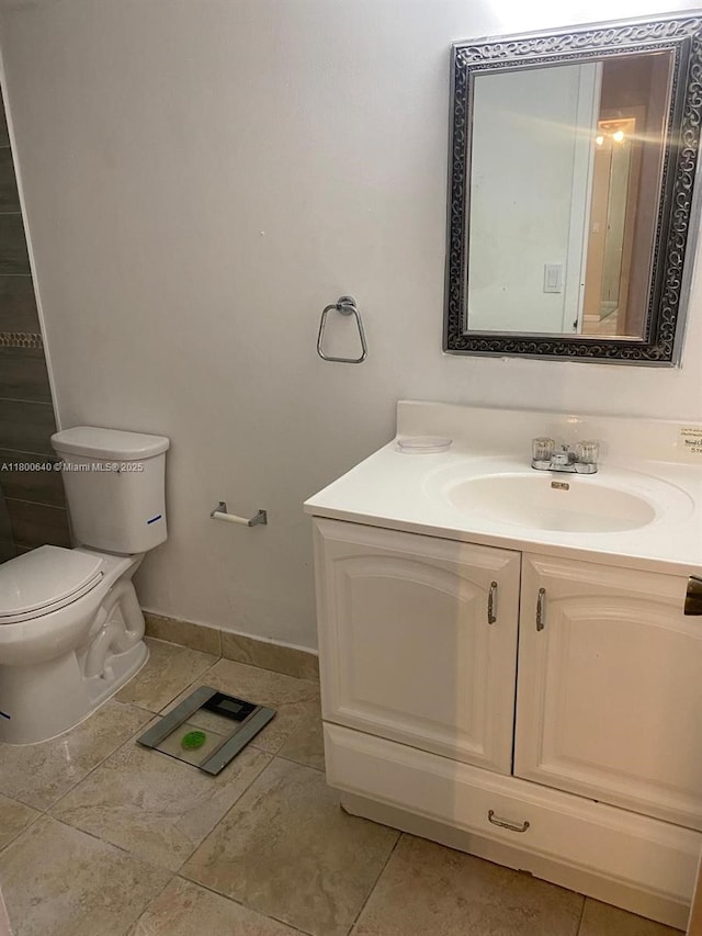 bathroom with vanity, toilet, and baseboards