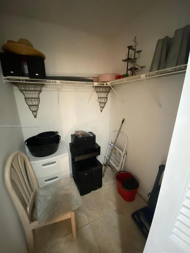 walk in closet with light tile patterned floors