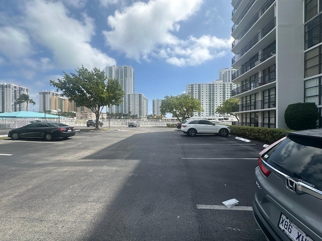 uncovered parking lot featuring a view of city
