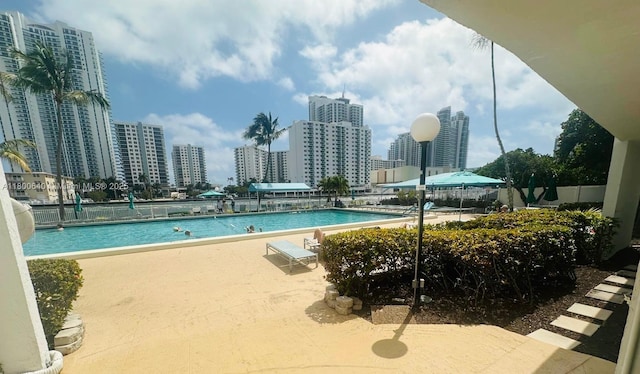 community pool with a patio and a city view
