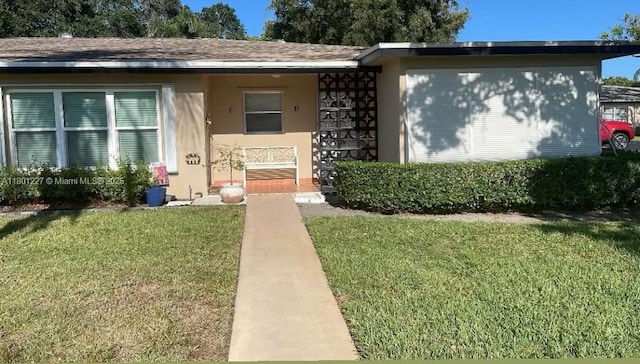 1022 Circle Dr Unit D, Delray Beach, FL 33445 - view of front facade featuring a front yard, stucco siding, and a porch