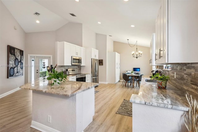 21660 Hammock Point Dr, Boca Raton, FL 33433 - kitchen featuring stainless steel appliances, high vaulted ceiling, a sink, backsplash, and light stone counters