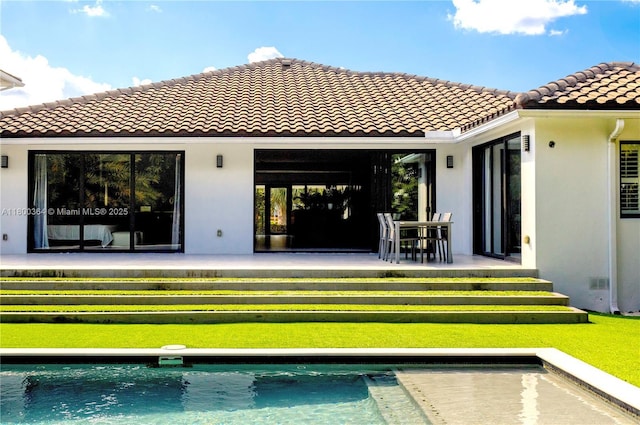 4275 Prairie Ave, Miami Beach, FL 33140 - back of house featuring a tile roof, stucco siding, and an outdoor pool