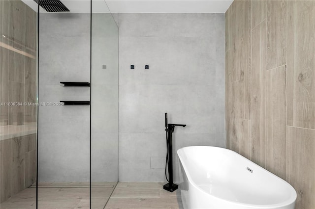 4275 Prairie Ave, Miami Beach, FL 33140 - full bathroom with a freestanding tub, a walk in shower, and tile walls