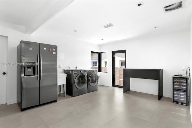 4275 Prairie Ave, Miami Beach, FL 33140 - laundry area featuring washing machine and clothes dryer, beverage cooler, baseboards, and light tile patterned flooring