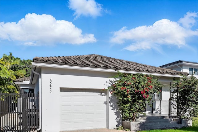 4275 Prairie Ave, Miami Beach, FL 33140 - view of front facade featuring a garage, stucco siding, and a tile roof