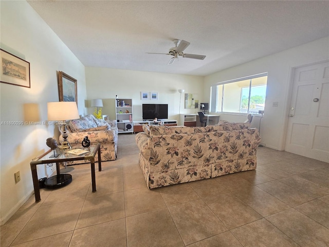 tiled living area with ceiling fan and baseboards