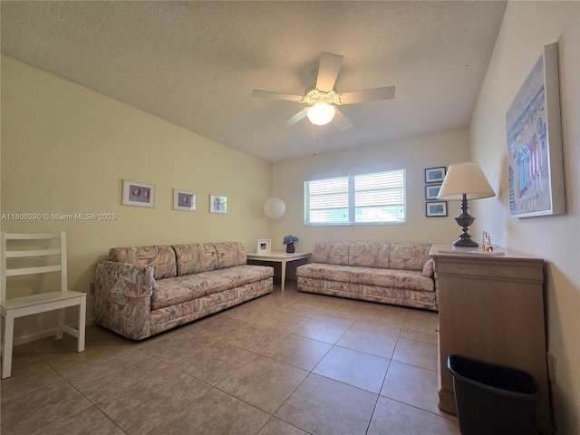living room with a ceiling fan, tile patterned floors, and a textured ceiling