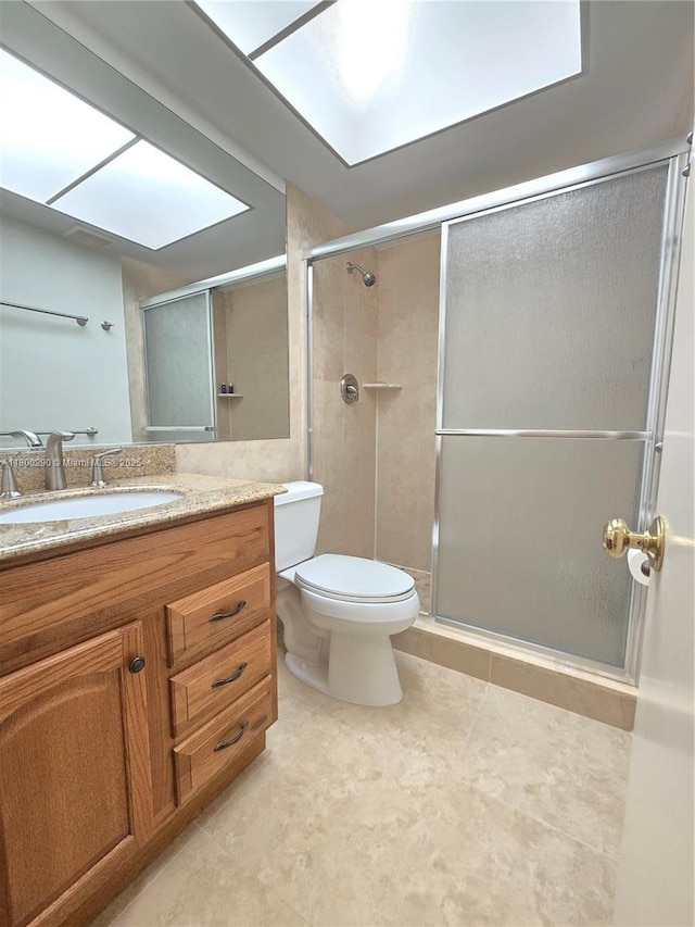 bathroom with a stall shower, toilet, and vanity