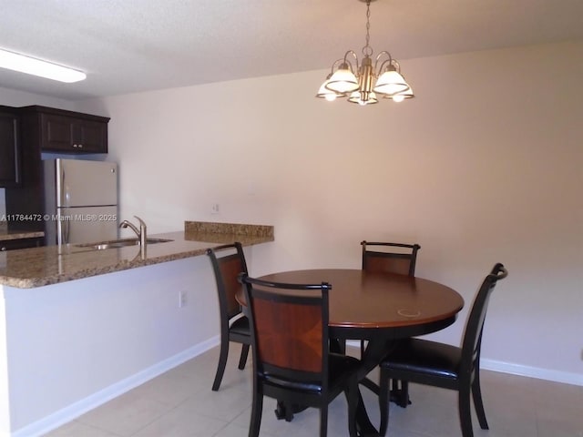 597 Green Springs Pl, West Palm Beach, FL 33409 - dining area with a chandelier, light tile patterned floors, and baseboards