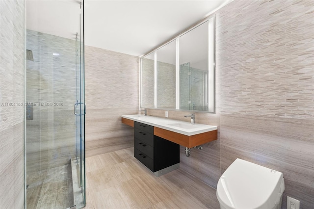 bathroom featuring tile walls, a stall shower, and vanity