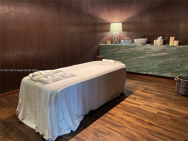 bedroom with wood finished floors and wood walls
