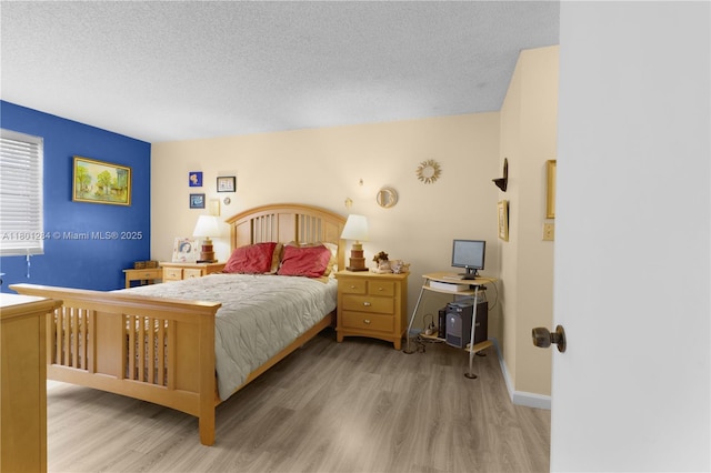 325 NW 72nd Ave Unit 308, Miami, FL 33126 - bedroom featuring wood finished floors, a textured ceiling, and baseboards