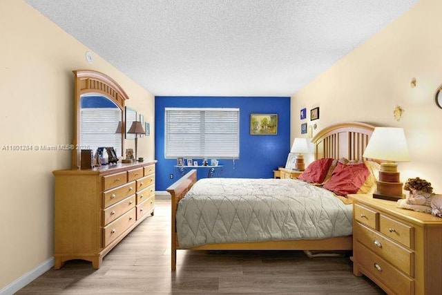 325 NW 72nd Ave Unit 308, Miami, FL 33126 - bedroom featuring a textured ceiling, light wood-type flooring, and baseboards