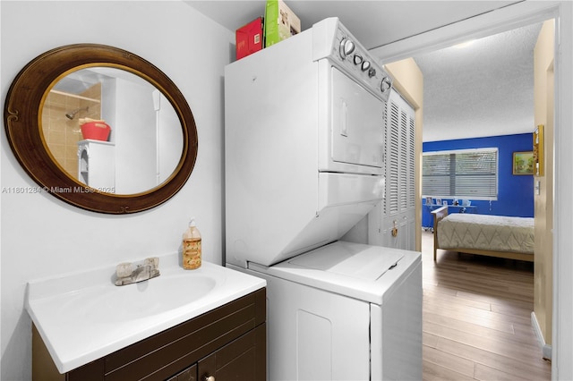 325 NW 72nd Ave Unit 308, Miami, FL 33126 - washroom with stacked washer and clothes dryer, a sink, and light wood-type flooring