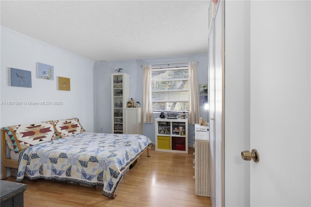 325 NW 72nd Ave Unit 308, Miami, FL 33126 - bedroom featuring light wood-style flooring and a textured ceiling