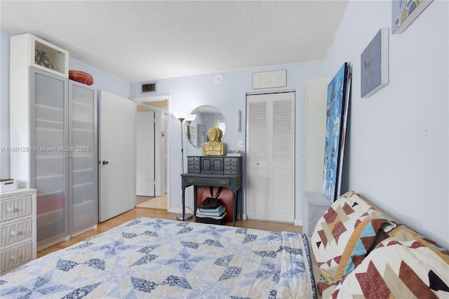 325 NW 72nd Ave Unit 308, Miami, FL 33126 - bedroom featuring a textured ceiling, light wood-type flooring, and a closet